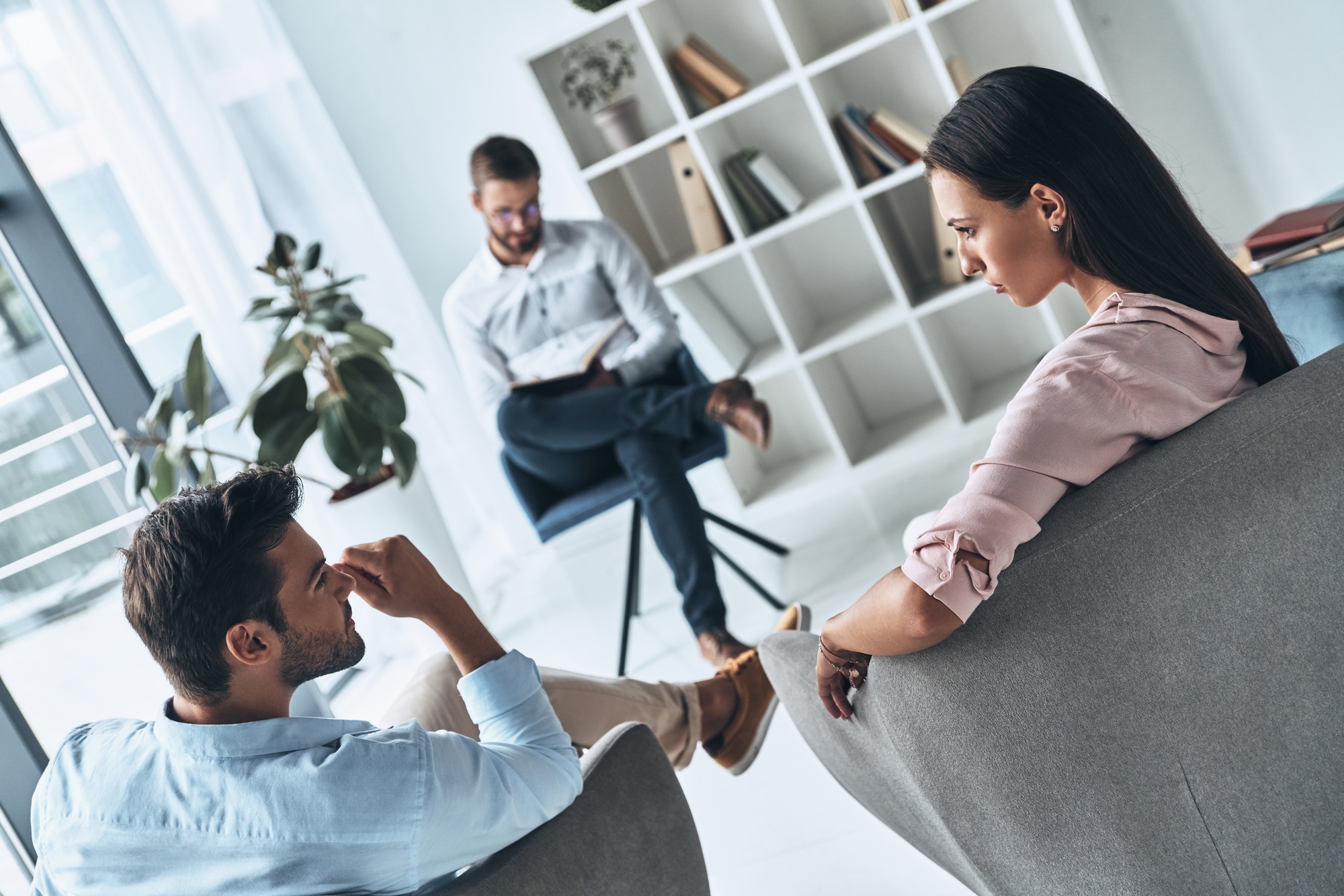Helping others. Young married couple talking while sitting on the therapy session with psychologist